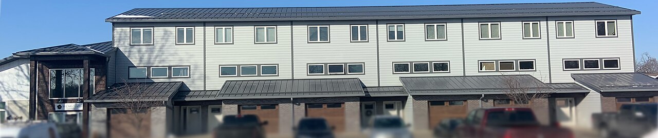 Dark standing-seam roof on a low-rise building, showing long panel runs