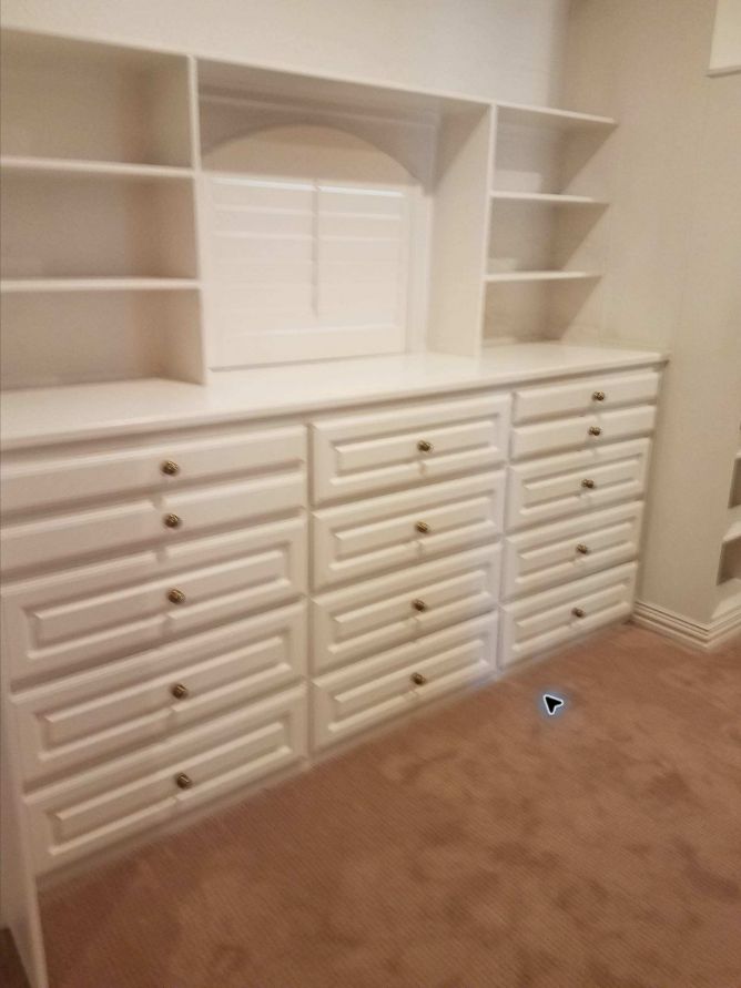 White custom closet storage with built-in drawers, shelving and brass hardware