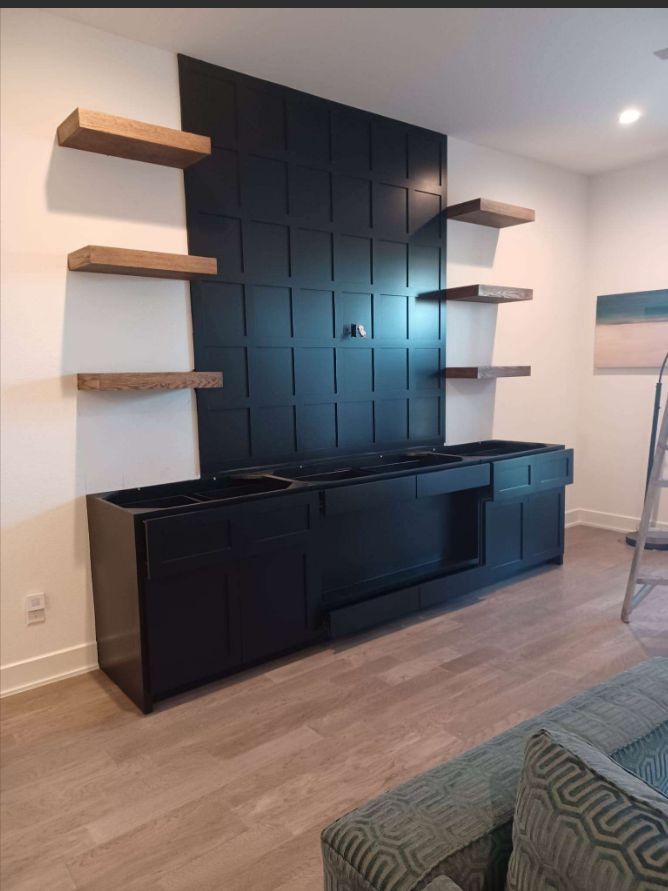 Custom black media wall with shaker cabinets and floating shelves