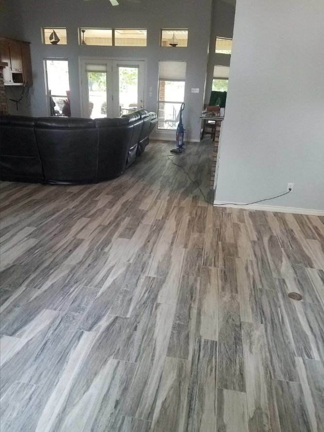 Finished gray wood-look plank flooring through an open living area