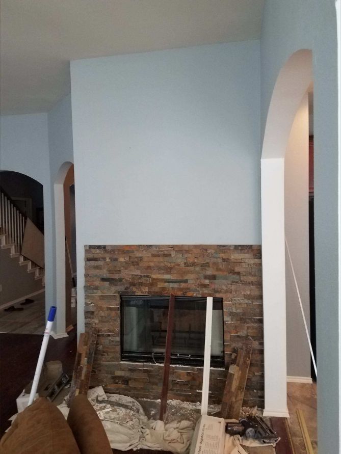 Stacked-stone fireplace surround during installation with the upper feature wall prepared for completion